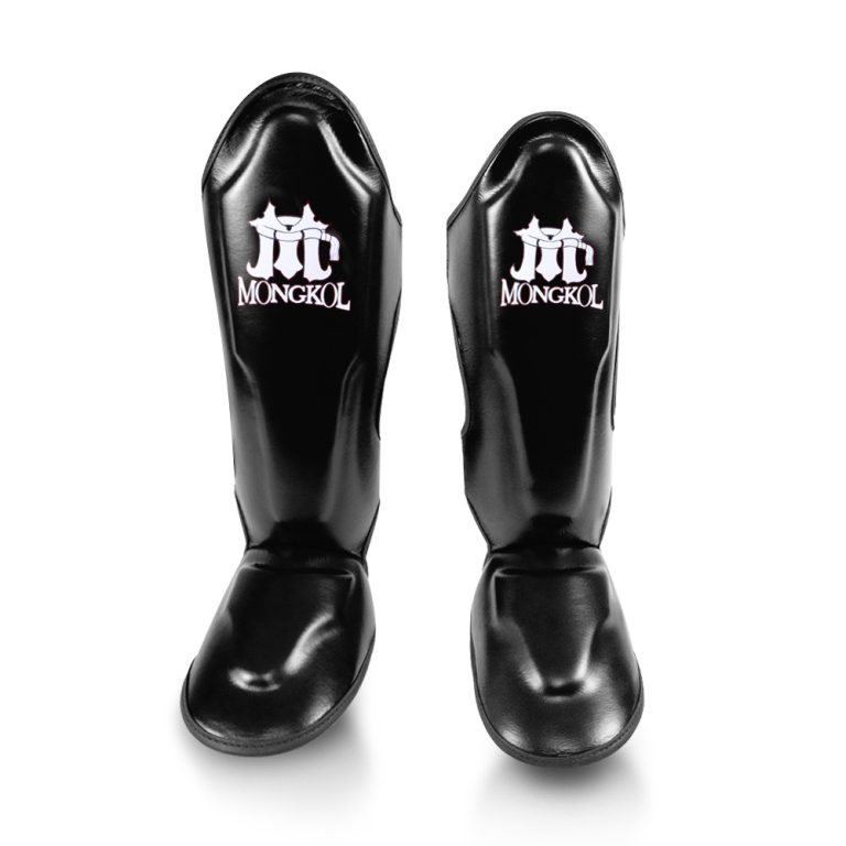 Paire de protege-tibias Mongkol SGM01 noirs vus de face, tibia et pied visibles, cuir noir matte
